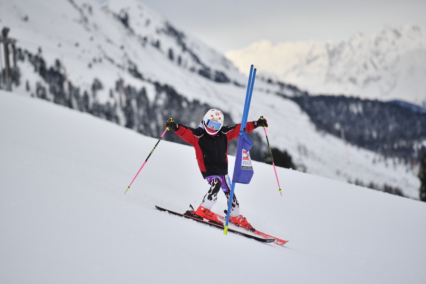 Junge Athletin im Slalom vor Bergkulisse